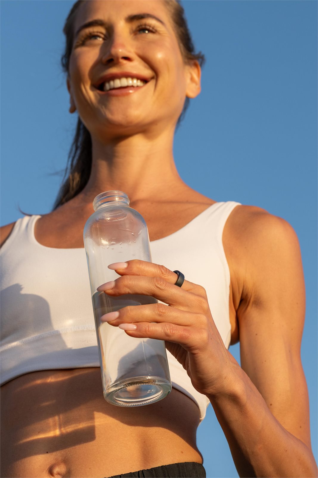 A runner holding a water bottle while wearing evobeing R1